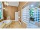 Elegant bathroom features a glass block shower, soaking tub, and designer finishes at 517 Kingsdown Ct, Waxhaw, NC 28173