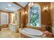 Luxurious bathroom featuring a soaking tub with stained glass window, and custom vanity at 517 Kingsdown Ct, Waxhaw, NC 28173