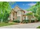 Stunning stone-clad home with lush landscaping, mature trees, and a welcoming entrance creating great curb appeal at 517 Kingsdown Ct, Waxhaw, NC 28173
