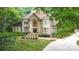 Elegant stone-front home with arched entry, well-manicured landscaping, and a curved driveway at 517 Kingsdown Ct, Waxhaw, NC 28173