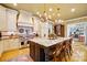 Open-concept kitchen featuring an oversized granite island, stainless steel appliances and decorative chandeliers at 517 Kingsdown Ct, Waxhaw, NC 28173