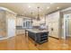 Well-appointed kitchen featuring a spacious center island with seating, custom cabinetry and modern lighting fixtures at 517 Kingsdown Ct, Waxhaw, NC 28173