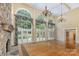 Bright and airy living room with soaring windows, stone fireplace and hardwood floors for a warm and inviting space at 517 Kingsdown Ct, Waxhaw, NC 28173