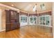 Spacious living room featuring hardwood floors, large windows with transoms and a custom built-in display cabinet at 517 Kingsdown Ct, Waxhaw, NC 28173