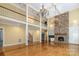 Open-concept living space with a soaring ceiling, stone fireplace, hardwood floors, and upper-level balcony for a grand feel at 517 Kingsdown Ct, Waxhaw, NC 28173