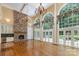 Spacious living room features a stone fireplace, tall windows, and hardwood floors for a bright, open, and luxurious feel at 517 Kingsdown Ct, Waxhaw, NC 28173