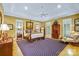 Spacious main bedroom with tray ceilings, a four-poster bed, and plantation shutters at 517 Kingsdown Ct, Waxhaw, NC 28173