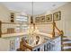 Open staircase with a decorative chandelier hanging above and hardwood steps at 517 Kingsdown Ct, Waxhaw, NC 28173
