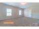 Spacious bedroom with neutral carpet, two windows for light, and a door leading to the walk-in closet at 524 Hullview Vis, Monroe, NC 28110
