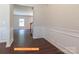 View of the foyer featuring wainscoting, luxury vinyl flooring, and an open entryway to the living spaces at 524 Hullview Vis, Monroe, NC 28110
