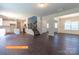 Open-concept living space flows into the kitchen and dining area, featuring wood floors and staircase at 524 Hullview Vis, Monroe, NC 28110