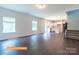 Open-concept living room leads to a modern kitchen and staircase with wood flooring and plenty of natural light at 524 Hullview Vis, Monroe, NC 28110