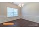 A dining room with wainscoting, dark flooring, chandelier, a window and an open concept layout at 524 Hullview Vis, Monroe, NC 28110