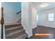 Carpeted stairway leading to the upper level, with a view of the entrance and the white wainscoting walls at 524 Hullview Vis, Monroe, NC 28110