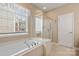A bathroom with tub, separate shower, and natural light at 56113 Finches Ct, Indian Land, SC 29707