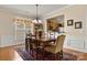 A dining room showcasing hardwood floors, curtains, and a pass through to the kitchen at 56113 Finches Ct, Indian Land, SC 29707