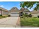 Inviting home with lush landscaping, a stone-accented entrance, and a spacious two-car garage at 56113 Finches Ct, Indian Land, SC 29707