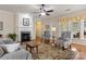 Cozy living room with a fireplace, hardwood floors, patterned chairs, and bright natural light at 56113 Finches Ct, Indian Land, SC 29707