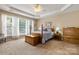 A main bedroom with neutral walls, tray ceiling, and natural light at 56113 Finches Ct, Indian Land, SC 29707