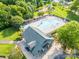 Aerial view of community pool area with blue building featuring mature trees, lounge chairs, and landscaping at 5963 Pale Moss Ln, Charlotte, NC 28269