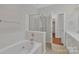 Bathroom features a soaking tub, glass-enclosed shower, and neutral-toned tile at 5963 Pale Moss Ln, Charlotte, NC 28269