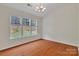 Well-lit bedroom with hardwood floors and large windows offering outdoor views at 5963 Pale Moss Ln, Charlotte, NC 28269