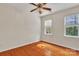 Empty bedroom with hardwood floors, ceiling fan and well lit windows at 5963 Pale Moss Ln, Charlotte, NC 28269