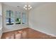 Bright dining room features hardwood floors, a chandelier, and views of the front yard at 5963 Pale Moss Ln, Charlotte, NC 28269