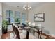 Modern dining room with glass table, white rug, and chandelier is bright and inviting at 5963 Pale Moss Ln, Charlotte, NC 28269
