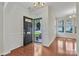 Bright foyer features gleaming hardwood floors, wainscoting, a chandelier, and black front door at 5963 Pale Moss Ln, Charlotte, NC 28269