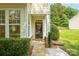 Inviting front entrance with a decorative wreath, stone accents, and manicured bushes at 5963 Pale Moss Ln, Charlotte, NC 28269
