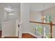 Hallway with hardwood floors, white bannister and a view of the home's chandelier at 5963 Pale Moss Ln, Charlotte, NC 28269
