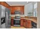 Well-lit kitchen features stainless steel appliances, wooden cabinets and a double basin sink with a view outside at 5963 Pale Moss Ln, Charlotte, NC 28269