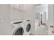 Functional laundry room includes a washer, dryer, and shelving at 5963 Pale Moss Ln, Charlotte, NC 28269