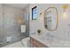 Modern bathroom featuring glass shower, wood vanity, and decorative lighting fixtures at 639 Edgemont Rd, Charlotte, NC 28211
