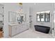 Elegant bathroom with a soaking tub, double vanity, marble flooring, and chic lighting fixtures at 639 Edgemont Rd, Charlotte, NC 28211