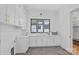 Bright laundry room with stylish herringbone flooring, ample cabinets, and a large window at 639 Edgemont Rd, Charlotte, NC 28211