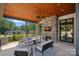 Covered patio with stone fireplace, comfortable seating, and a view of the backyard at 639 Edgemont Rd, Charlotte, NC 28211