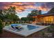 Stunning twilight view of a modern home's pool area, featuring a spa, lounge chairs, and ambient lighting at 639 Edgemont Rd, Charlotte, NC 28211