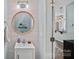 Cozy bathroom with wood paneled walls, a round mirror and modern fixtures at 6834 Creft Cir, Indian Trail, NC 28079