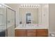 Bright bathroom with a double vanity, a large mirror, and a glass-enclosed shower at 6834 Creft Cir, Indian Trail, NC 28079