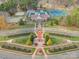 Aerial view of a clock tower in the center of a park with landscaped gardens and manicured lawns at 6834 Creft Cir, Indian Trail, NC 28079