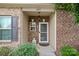 Charming front porch with brick facade, black shutters, and a well-manicured garden at 6834 Creft Cir, Indian Trail, NC 28079