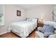 Serene bedroom featuring hardwood floors, a cozy armchair, and a bedside table with lamp at 7526 Shadowstone Dr, Charlotte, NC 28270