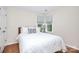 Bright bedroom featuring two windows, light hardwood floors, and white trim and doors at 7526 Shadowstone Dr, Charlotte, NC 28270