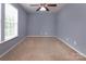 Neutral bedroom features carpeted floor, ceiling fan, and natural light from a window at 7623 Monarch Birch Ln, Charlotte, NC 28215