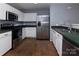 Well-equipped kitchen with stainless steel appliances, white cabinets, and green countertops at 7623 Monarch Birch Ln, Charlotte, NC 28215