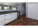 Kitchen featuring white cabinets, stainless dishwasher and sink overlooking the living area at 7623 Monarch Birch Ln, Charlotte, NC 28215