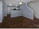 Open-concept living area with wood-look flooring, steps to second floor, and kitchen view at 7623 Monarch Birch Ln, Charlotte, NC 28215
