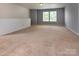 An open-concept living area with neutral carpet and abundant light at 7623 Monarch Birch Ln, Charlotte, NC 28215
